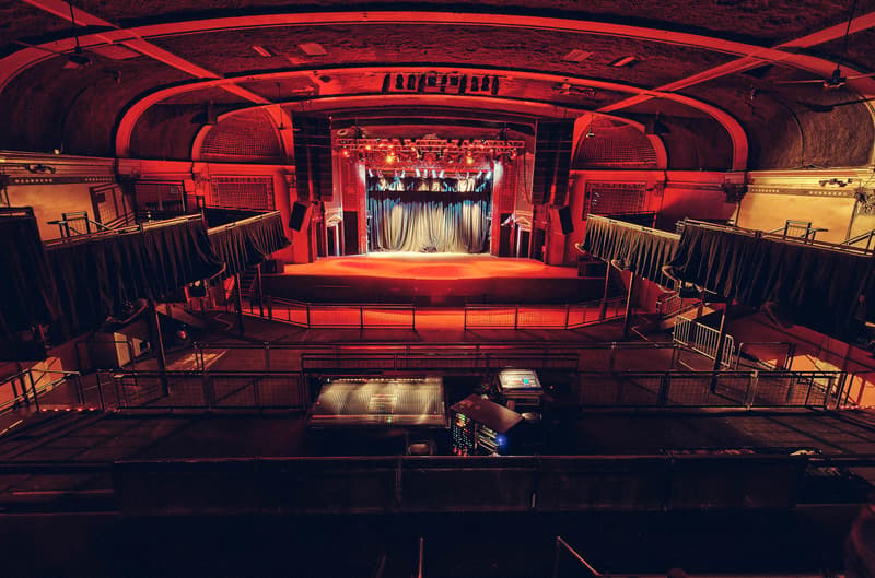Empty red-lit Ogden room seen from the balcony facing the stage