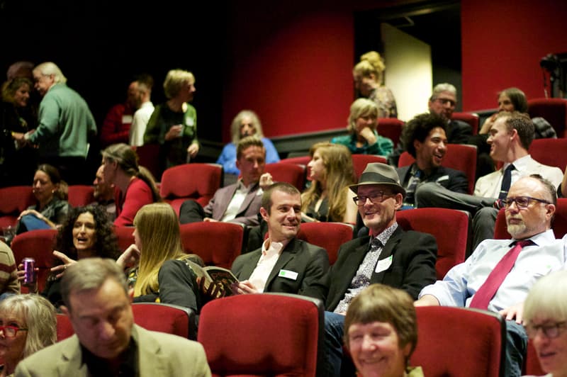 Audience seated in red theater seats at the Dairy