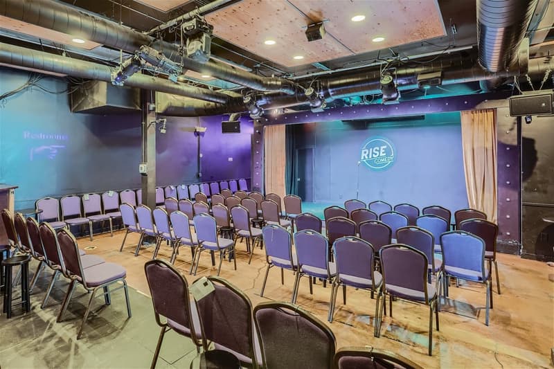 Theatre seating facing the RISE Comedy stage under stage lights