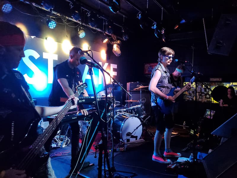 Band playing on the lit stage under the Lost Lake sign