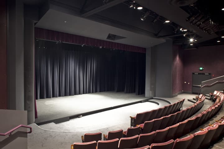 Empty stage with black curtain seen from the audience seats